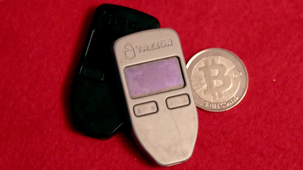 Аппаратные криптокошельки Trezor и сувенирная монета биткоин